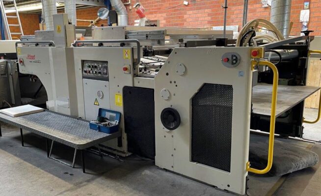 دستگاه UV موضعی ساکورایی در حال اجرای پوشش براق و برجسته روی جعبه و کاتالوگ